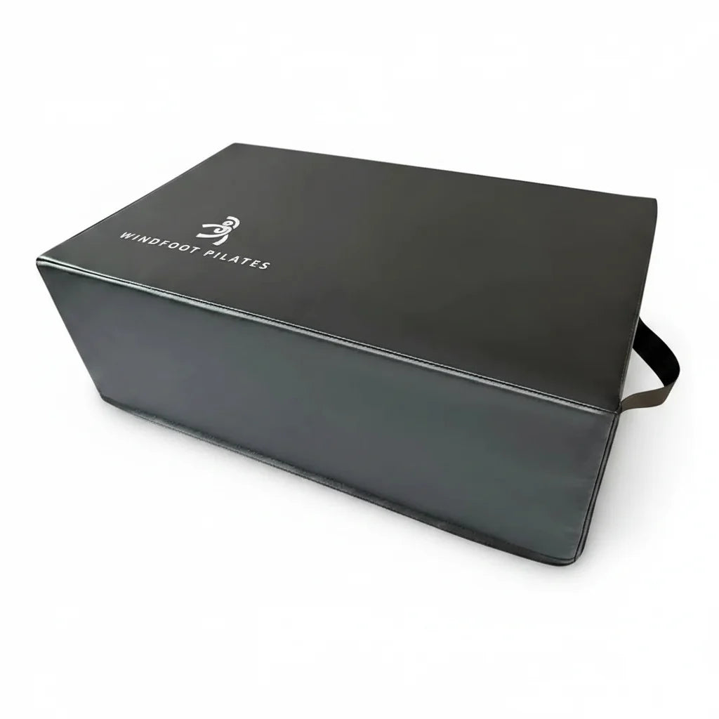 Pilates reformer box placed on a reformer for seated and short-box practice